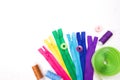 Bright colorful zippers, threads in different spools, Velcro in a roll lie on a white background