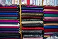 Bright colors fabric rack, pile of colorful traditional fabrics