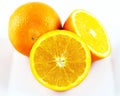 Two whole and halved oranges on white. Royalty Free Stock Photo