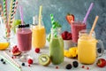 Bright and colourful fruit smoothies with colourful straws, ready for drinking.