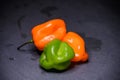 Bright colourful green and orange habanero hot peppers on table