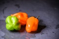 Bright colourful green and orange habanero hot peppers on table