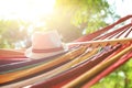 Bright comfortable hammock with hat hanging in garden, closeup