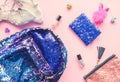 Bright composition of fashion accessories. Glitter sequins backpack, purse, funny pen, nail polish and hair elastic bands.