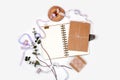 Bright composition with a spiral notebook, eucalyptus, silk ribbons and kraft paper on a white background. Photos for