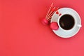 Bright concept for Valentine`s day. Cup of tea and raspberry macaroons on red background. Trending Panton color