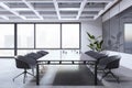 Bright conference room interior with furniture, concrete flooring and window and city view.