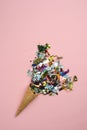 Bright confetti ice cream with ice cream cone on pink background. Winter holiday party concept. minimalism layout. flat lay style.