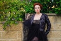 A bright confident beautiful red-haired woman in a black leather jacket, lace sexy dress. Against a background of yellow Royalty Free Stock Photo