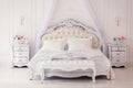 Bright, cozy stylish interior bedroom beautiful rich antique furniture four-poster bed with canopy