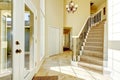 Bright creamy tones entryway with staircase and tile flooring.