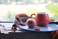 Bright cup with coffee on a window background, apples on a plate, warm scarf, leaves