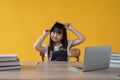 A bright and cute young Asian girl holding a book over her head, smiling at the camera Royalty Free Stock Photo