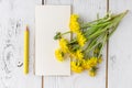 Bright dandelions, notebook with a blank page for Your inscriptions, vintage spoons on a beautiful, white, wooden table Royalty Free Stock Photo