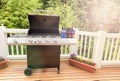 Bright daylight on deck wiht open barbecue cooker and bottled be