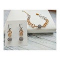 Bright decorations on a light background. A graceful bracelet and unusual earrings with a large chain.