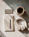 Coffee, headphones, notebook and smartphone on bright desk, AI generated Royalty Free Stock Photo