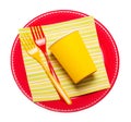 Bright disposable plates, paper cups, plastic forks napkin isolated.