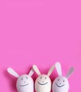 A bright Easter composition - three pink eggshell hares on a pink background.