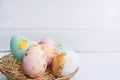 Bright easter eggs with in basket, on white wood Royalty Free Stock Photo