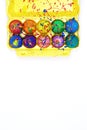Bright Easter eggs painted with gouache in yellow egg box isolated on white background  top view copy space  vertical image Royalty Free Stock Photo