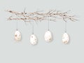 Bright Easter eggs with small spots hang on branches