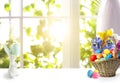 Bright Easter eggs in wicker basket and bunny figure on table Royalty Free Stock Photo