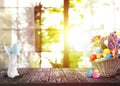 Bright Easter eggs in wicker basket and bunny figure on table Royalty Free Stock Photo