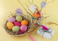 Bright Easter eggs in a wicker basket with a gift for Easter Royalty Free Stock Photo
