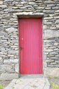 Bright entry red door of old stone building Royalty Free Stock Photo
