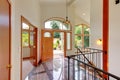 Bright entry way with tile floor and staircase with metal railings.