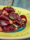 On a bright ethnic plate is a vegetarian lean beet salad, green