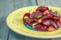 On a bright ethnic plate is a vegetarian lean beet salad, green