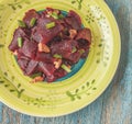 On a bright ethnic plate is a vegetarian lean beet salad, green