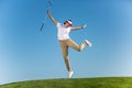 Cheerful woman jumping on golf course Royalty Free Stock Photo