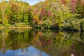 Bright fall colors reflecting in blue water pond Royalty Free Stock Photo