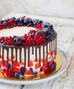Bright festive cake with berries and chocolate on a white wooden background Royalty Free Stock Photo