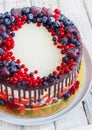 Bright festive cake with berries and chocolate on a white wooden background Royalty Free Stock Photo