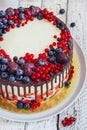 Bright festive cake with berries and chocolate on a white wooden background Royalty Free Stock Photo