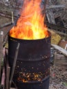 Bright fire burning inside an old rusty barrel