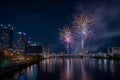 Bright fireworks explode above the Pittsburgh skyline, reflecting in the river below. The vibrant colors illuminate buildings and Royalty Free Stock Photo