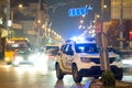 Bright flashing blue lights of police patrol car parked on city street with night traffic Royalty Free Stock Photo