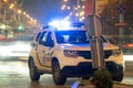 Bright flashing blue lights of police patrol car parked on city street with night traffic Royalty Free Stock Photo