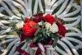 Bright flower arrangement of red and white roses on light blurry background, close-up. Wedding bouquet of fresh flowers with green Royalty Free Stock Photo