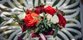 Bright flower arrangement of red and white roses on light blurry background, close-up. Wedding bouquet of fresh flowers with green Royalty Free Stock Photo