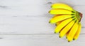 Bright fresh mini bananas on gray wooden background Royalty Free Stock Photo