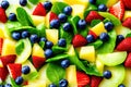 Bright fruit and berry salad with strawberries, blueberries, melon and green leaves Royalty Free Stock Photo