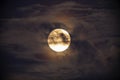 Bright full moon against dark clouds