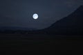 Bright full moon over forest on mountains in evening of summer Royalty Free Stock Photo