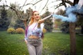 A bright girl with glitter makeup and African braids in a bluish shirt takes refuge in artificial smoke in a park full Royalty Free Stock Photo